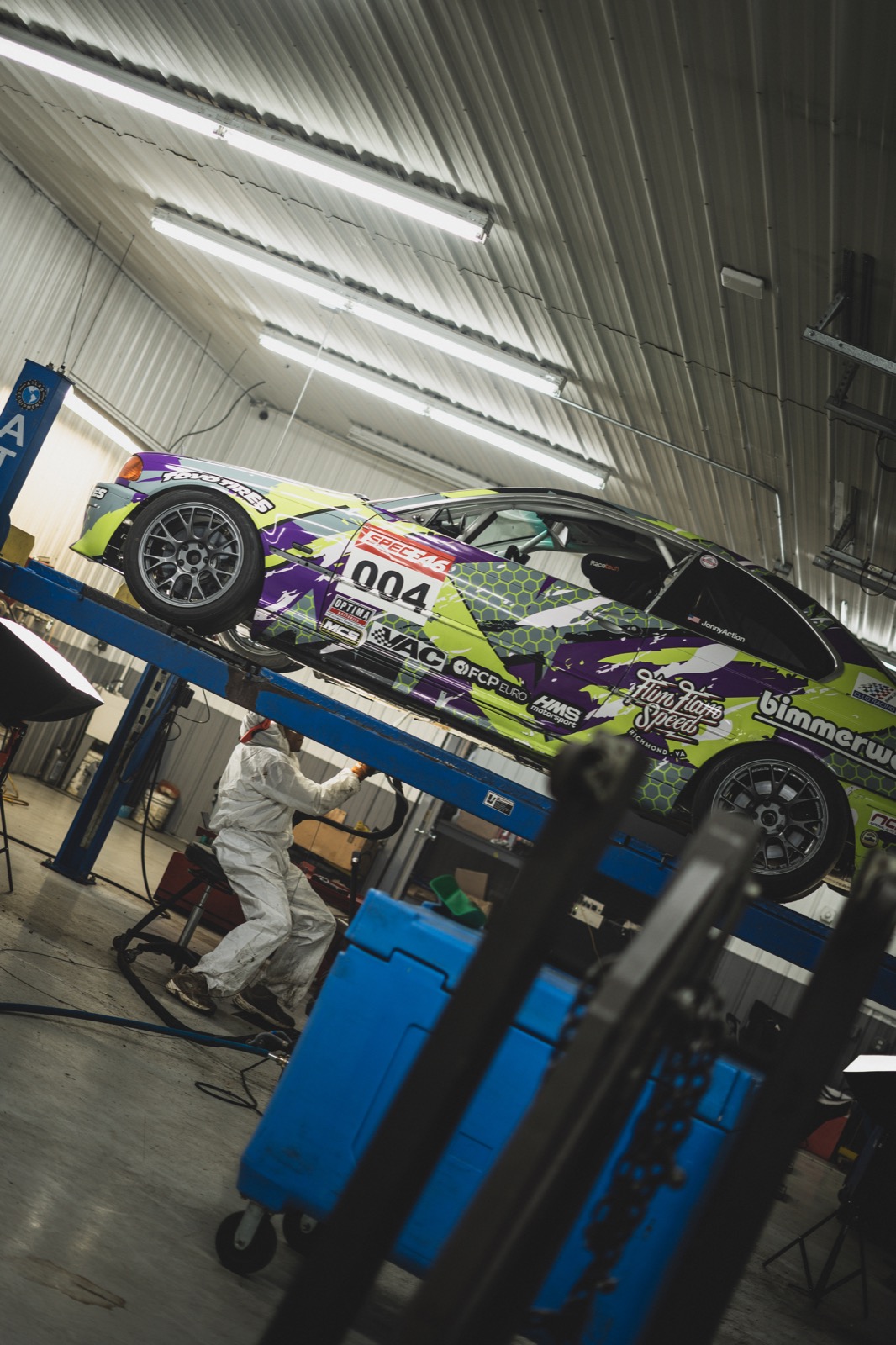 BMW race car on lift being dry ice blasted